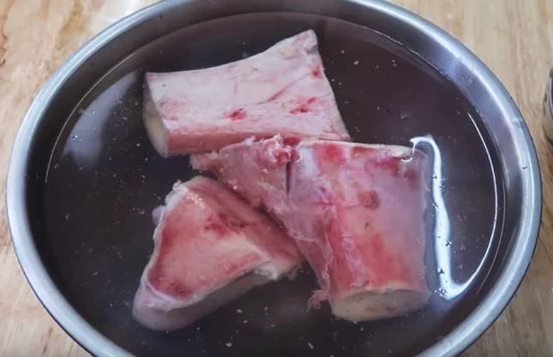 Ngâm xương bò với nước muối, chanh và gừng để khử mùi hôi
